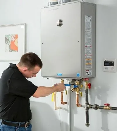 Technician servicing a wall-mounted gas geyser